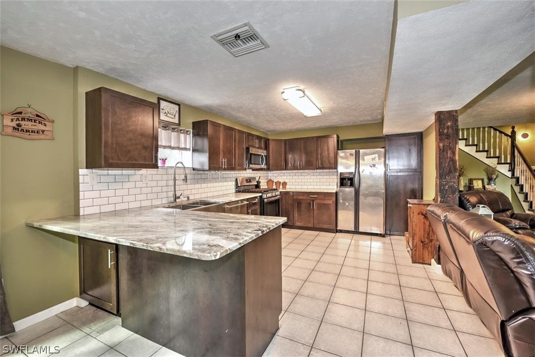 5320 Obannon Road Fort Myers, FL 33905 - Photo 8 of 28 a kitchen with stainless steel appliances granite countertop a sink stove and refrigerator