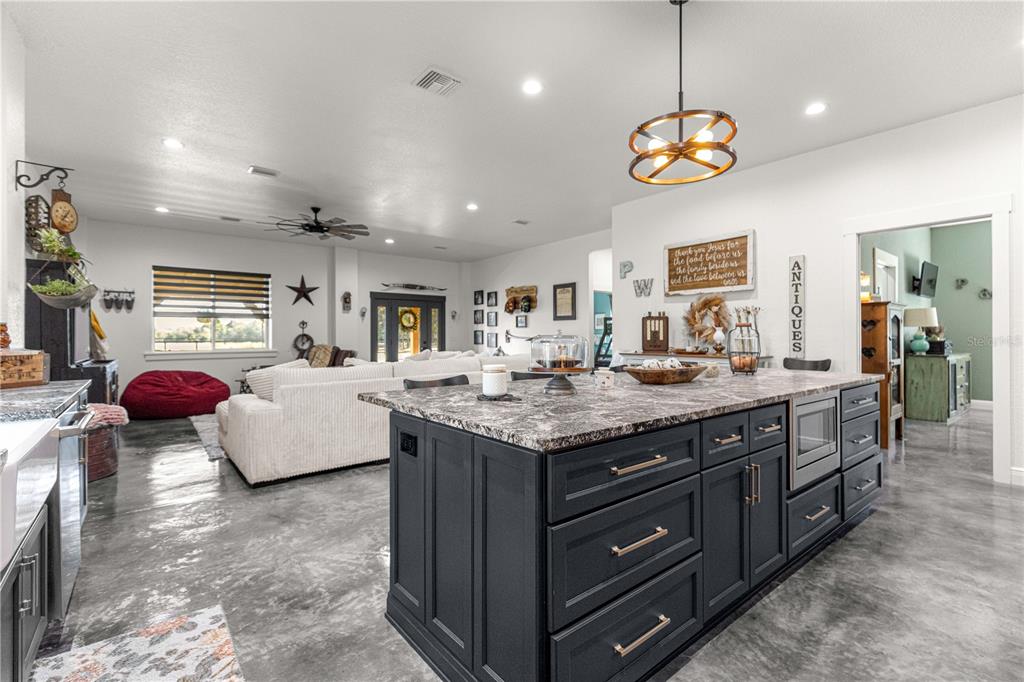 4120 Southwest 199th Court Dunnellon, FL 34431 - Photo 37 of 82 a kitchen with granite countertop a stove a sink a oven and a dining table