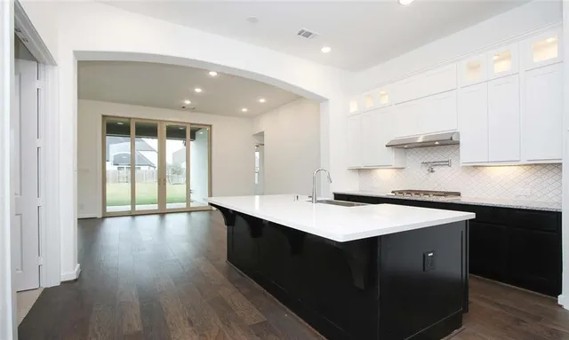 a kitchen with a sink and a stove top oven