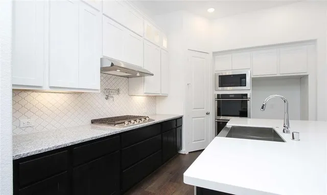 a kitchen with a sink a stove and refrigerator