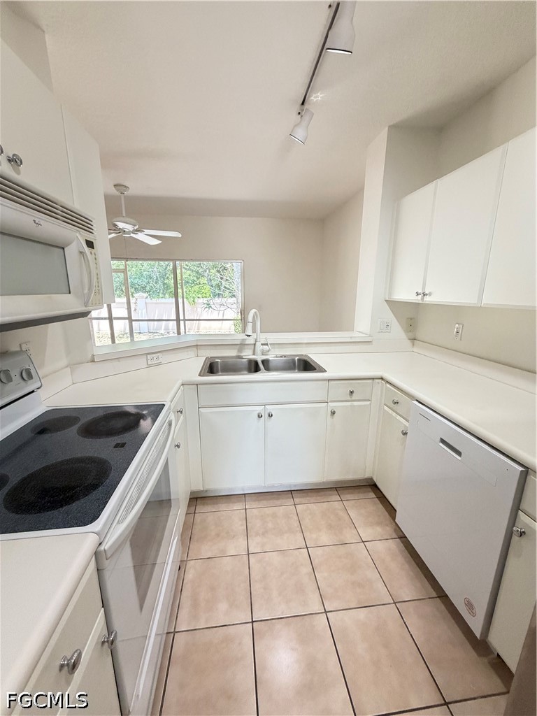 8541 Athena Court Lehigh Acres, FL 33971 - Photo 6 of 17 a kitchen with a sink a stove a microwave and cabinets