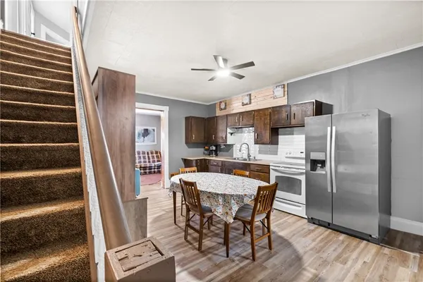 a view of kitchen with refrigerator stove and wooden floor