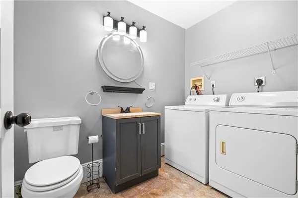 a bathroom with a toilet sink vanity and mirror