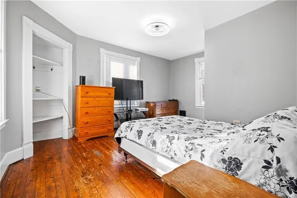 a bedroom with a bed and wooden floor