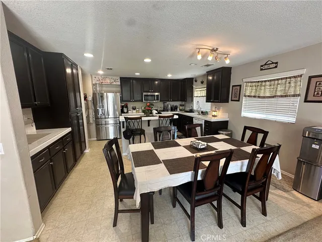 a kitchen with a sink a stove a refrigerator a kitchen island and chairs