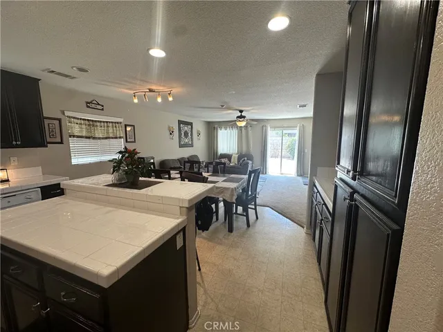 a kitchen with stainless steel appliances a sink a stove a refrigerator cabinets and a dining table