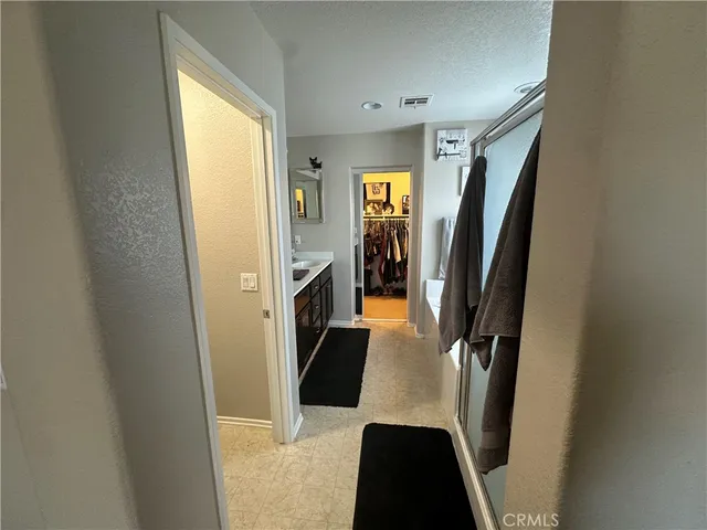 a view of walk in closet with clothes