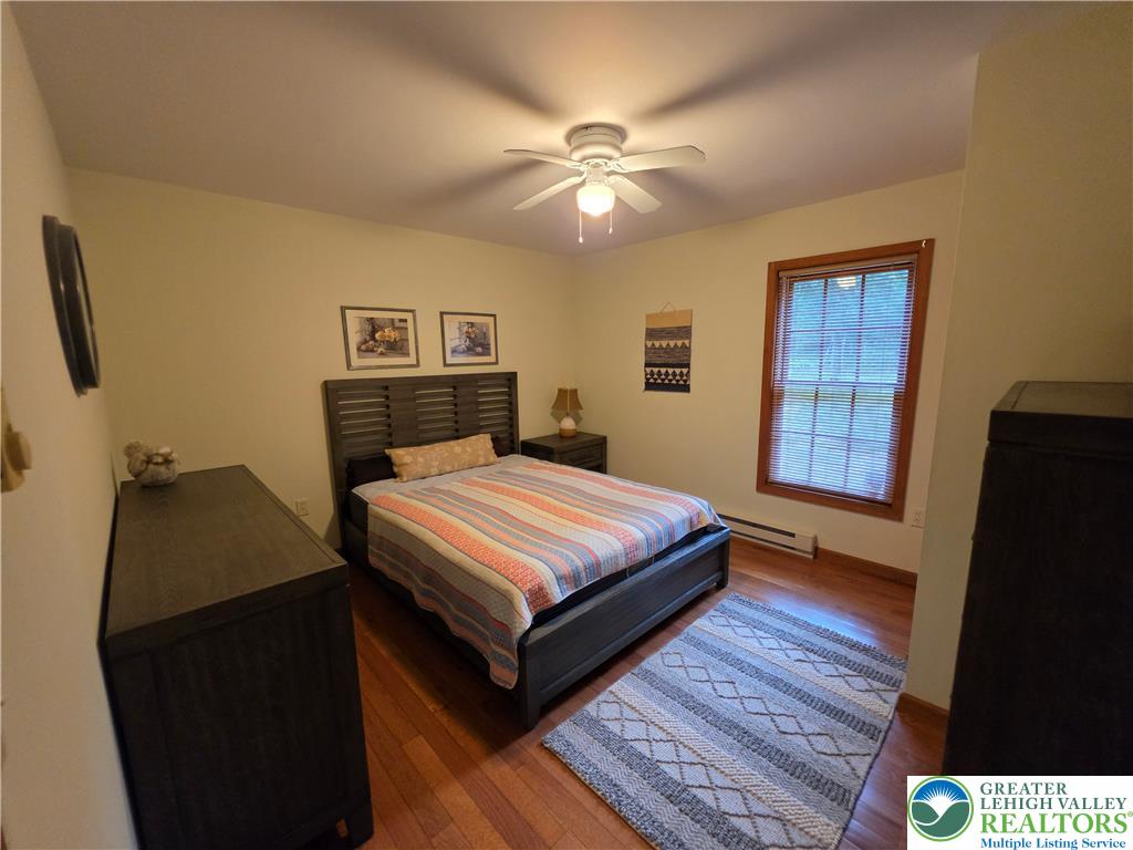 211 Murphy Circle Bushkill, PA 18324 - Photo 17 of 28 Well-lit sleeping quarters featuring rich hardwood flooring and a functional ceiling fan.