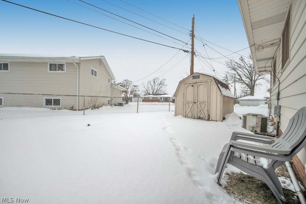 6846 Revere Road Cleveland, OH 44130 - Photo 9 of 30 Yard covered in snow with a fenced backyard and a storage shed