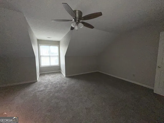 an empty room with a ceiling fan and window