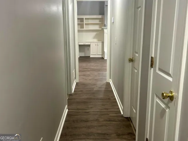 a view of a hallway with wooden floor and entryway