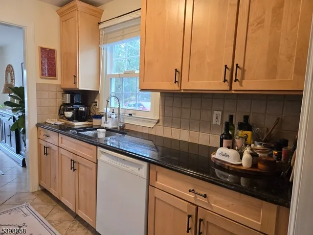a kitchen with stainless steel appliances granite countertop white cabinets and a sink