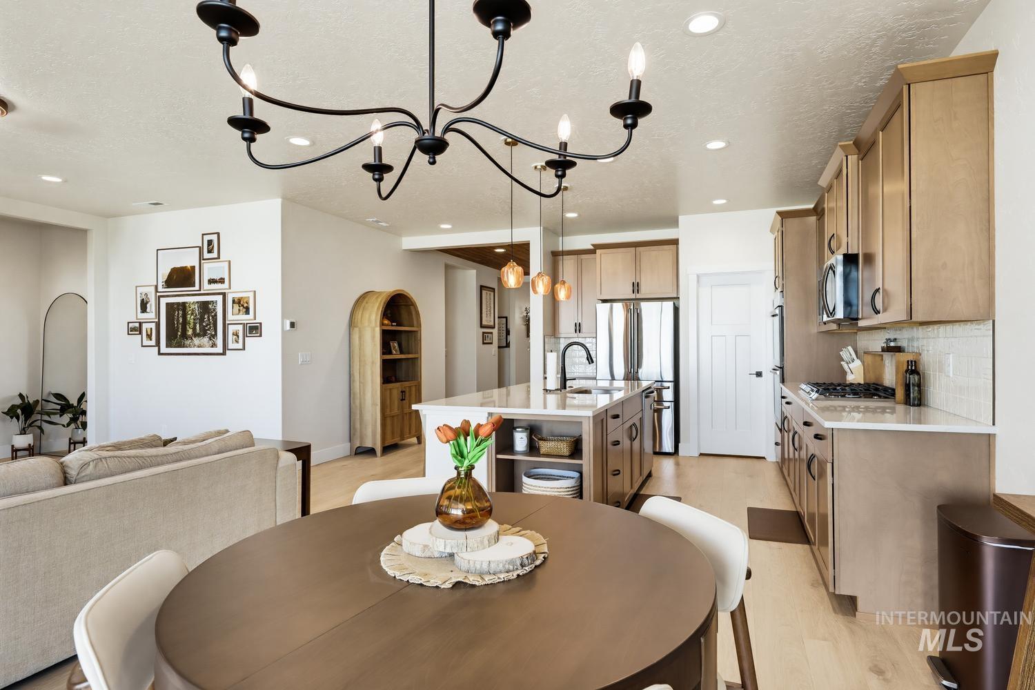 5990 West Ladle Rpds Street Meridian, ID 83646 - Photo 20 of 42 Open-concept living area with a contemporary chandelier, recessed lighting, and wood-finish flooring