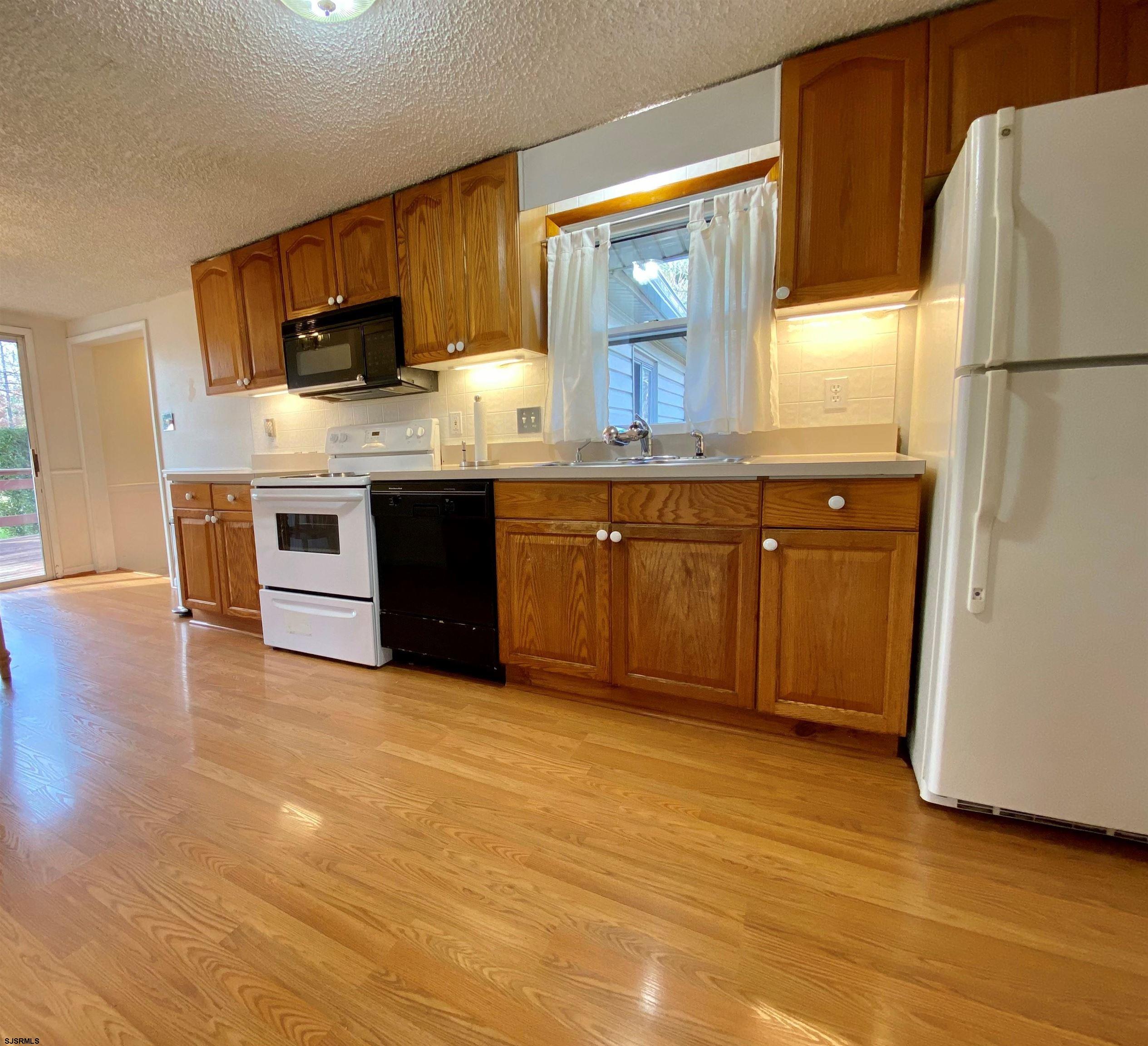 201 Broad Street Milmay, NJ 08340 - Photo 6 of 23 a kitchen with stainless steel appliances granite countertop a refrigerator a stove a sink and a microwave