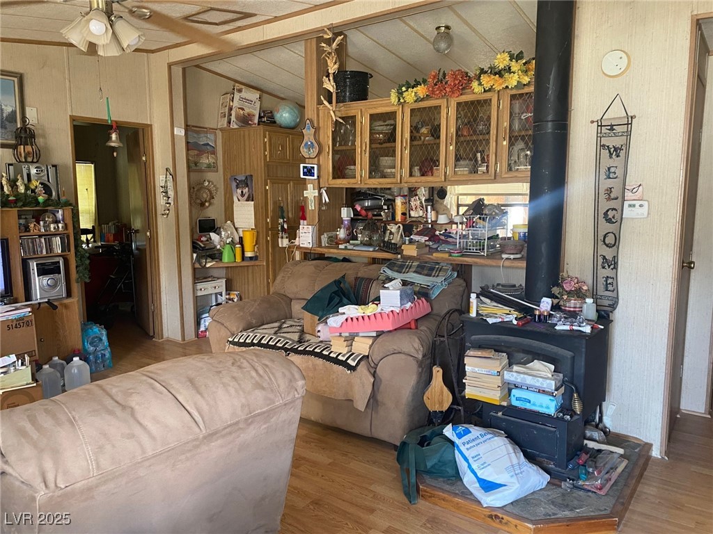 18 Pine Street Ruth, NV 89319 - Photo 3 of 12 Living area featuring a wood stove, ceiling fan, wood finished floors, and vaulted ceiling
