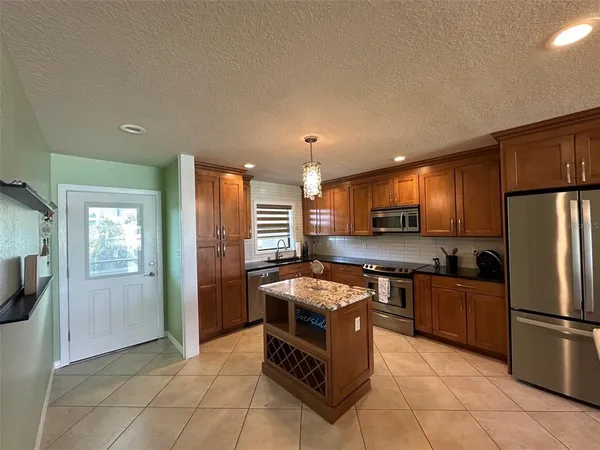 a kitchen with stainless steel appliances granite countertop a stove a sink dishwasher a refrigerator and a microwave