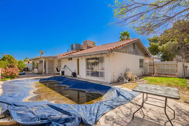 a view of backyard with swimming pool and furniture