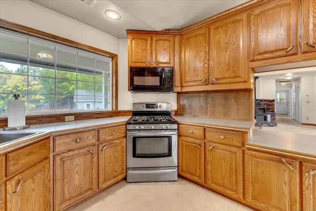 an empty room with chandelier fan and windows
