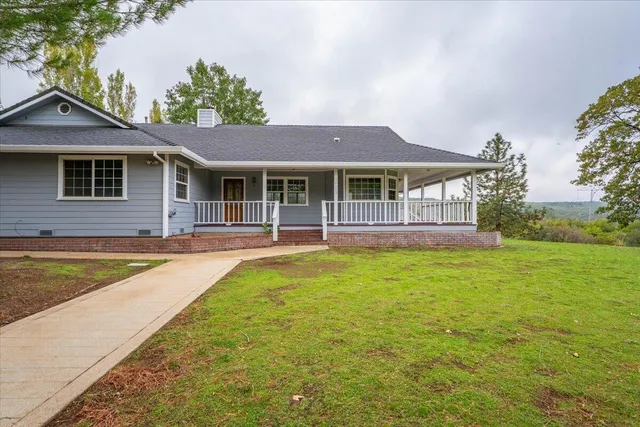 a view of a house with a garden and trees