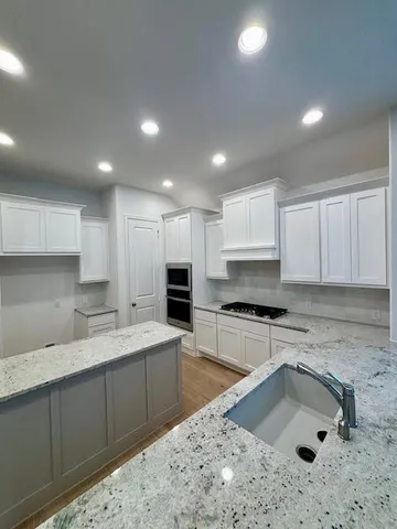 a kitchen with a sink stove and cabinets