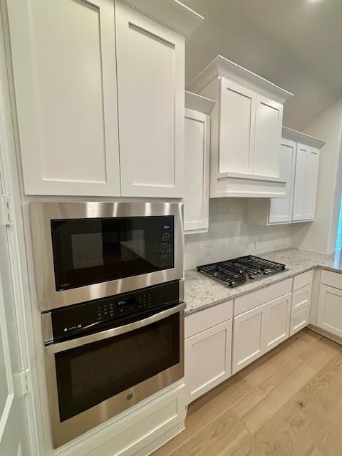 14910 Slough View Court Magnolia, TX 77354 - Photo 13 of 37 a kitchen with granite countertop a stove and a microwave