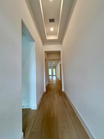 a view of a hallway with wooden floor and a fireplace