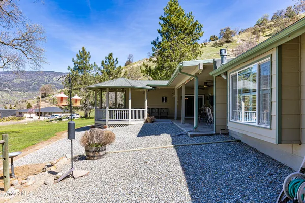 a kitchen with stainless steel appliances granite countertop a stove top oven a sink dishwasher a dining table and chairs with wooden floor