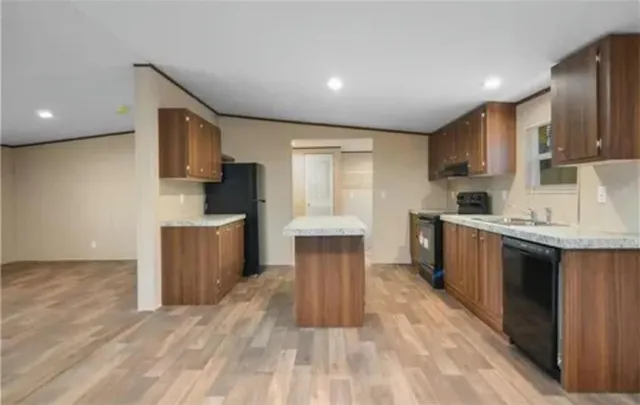 a kitchen with granite countertop a sink cabinets and stainless steel appliances