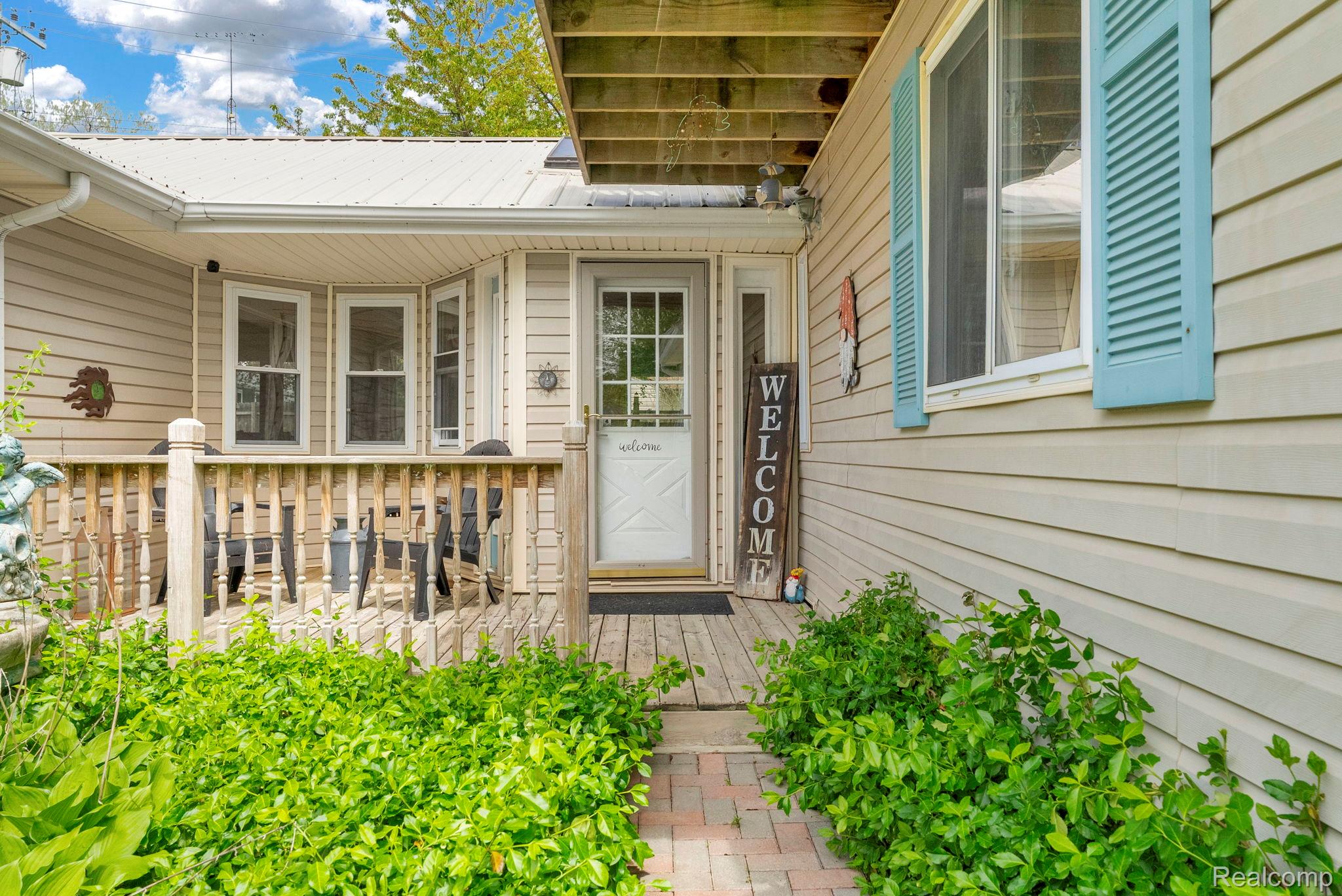 7489 Aspen Road Lexington, MI 48450 - Photo 10 of 62 Front exterior with light-colored siding and a covered porch