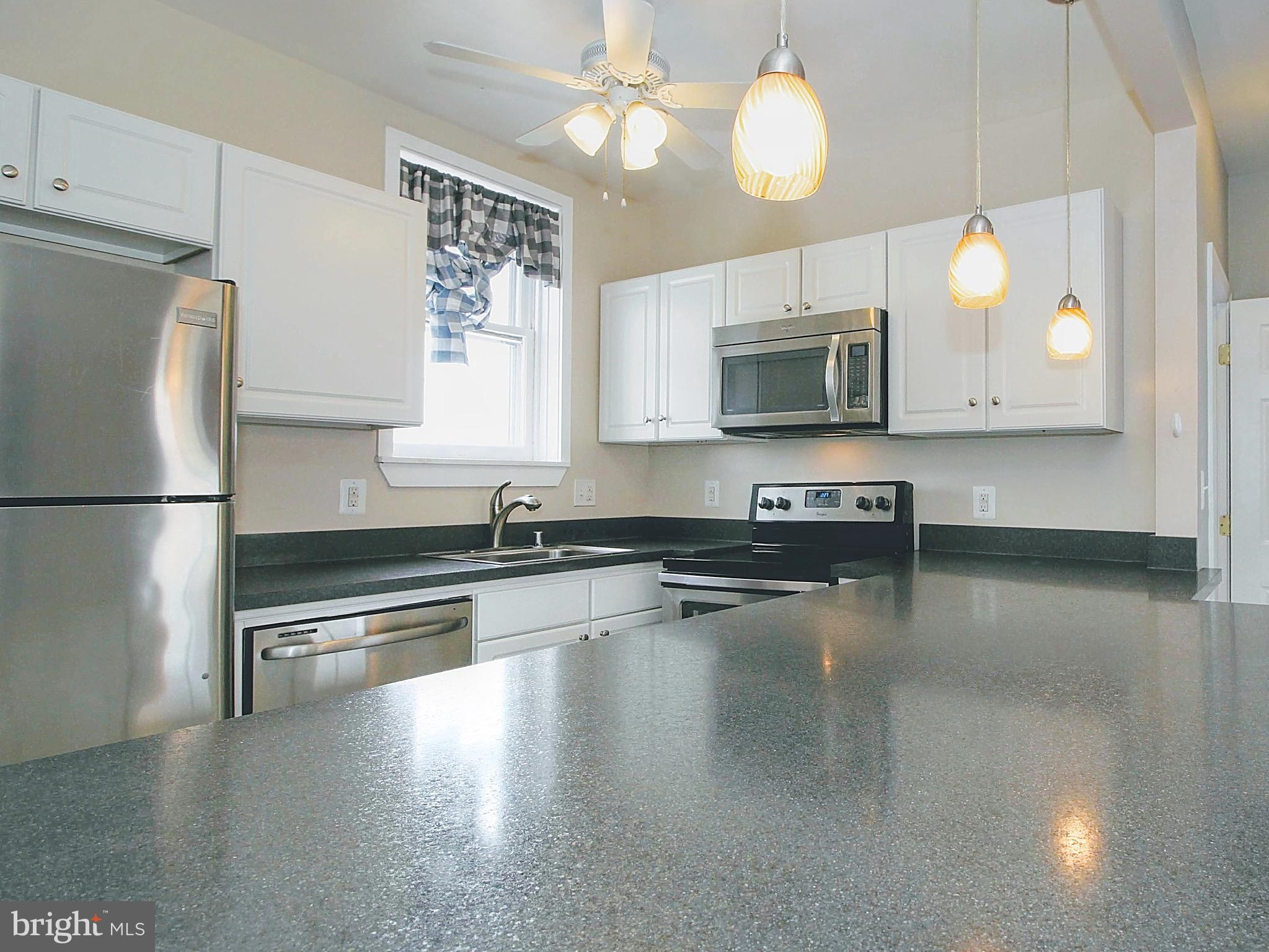 22 North Market Street, Unit 3 Frederick, MD 21701 - Photo 16 of 16 a kitchen with stainless steel appliances granite countertop a refrigerator a stove a microwave oven a sink dishwasher and white cabinets with wooden floor