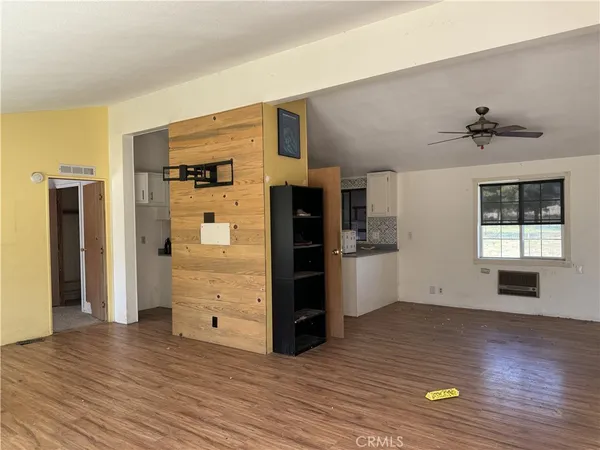 a view of a kitchen with a fridge wooden floor and a window