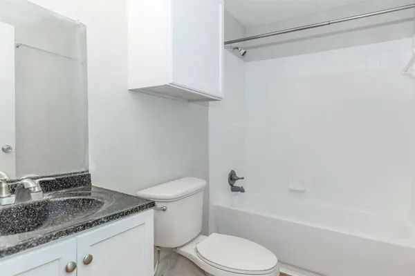 a white toilet sitting next to a bath tub