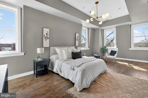 a spacious bedroom with a bed and a chandelier