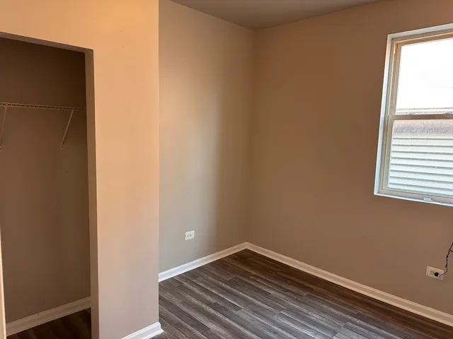 a view of a small space with wooden floor and a window