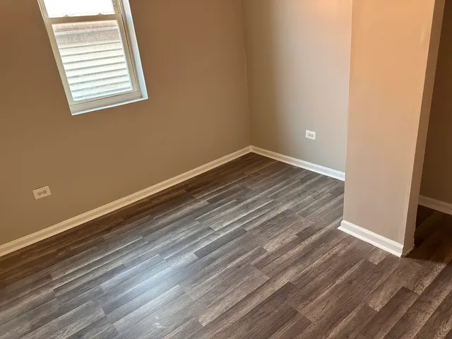 a view of a room with wooden floor and window