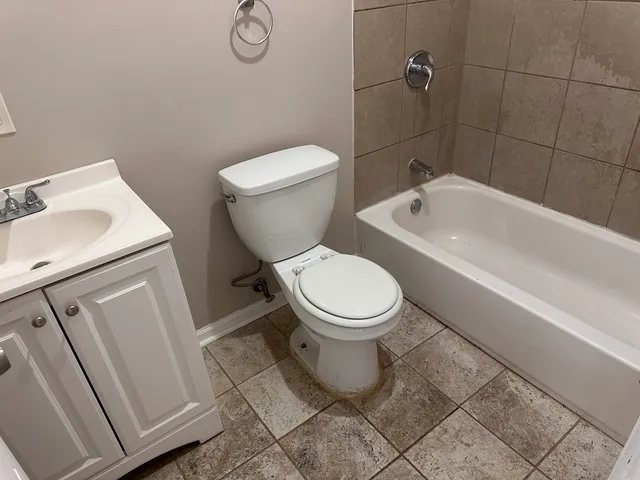 a white toilet sitting next to a bath tub