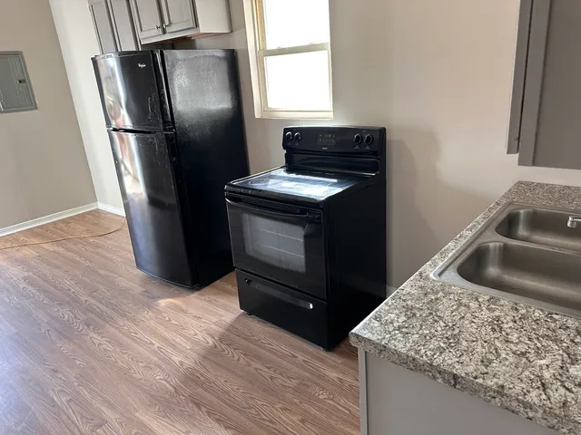 a kitchen with stainless steel appliances granite countertop a refrigerator a sink a stove and dishwasher