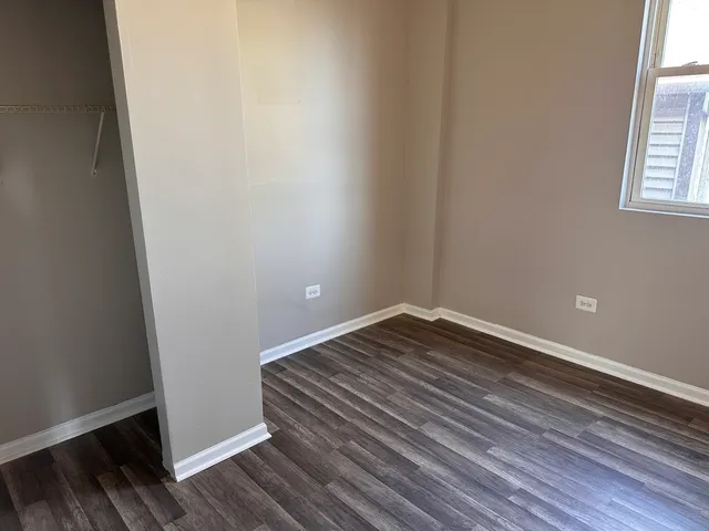 a view of a room with wooden floor and window