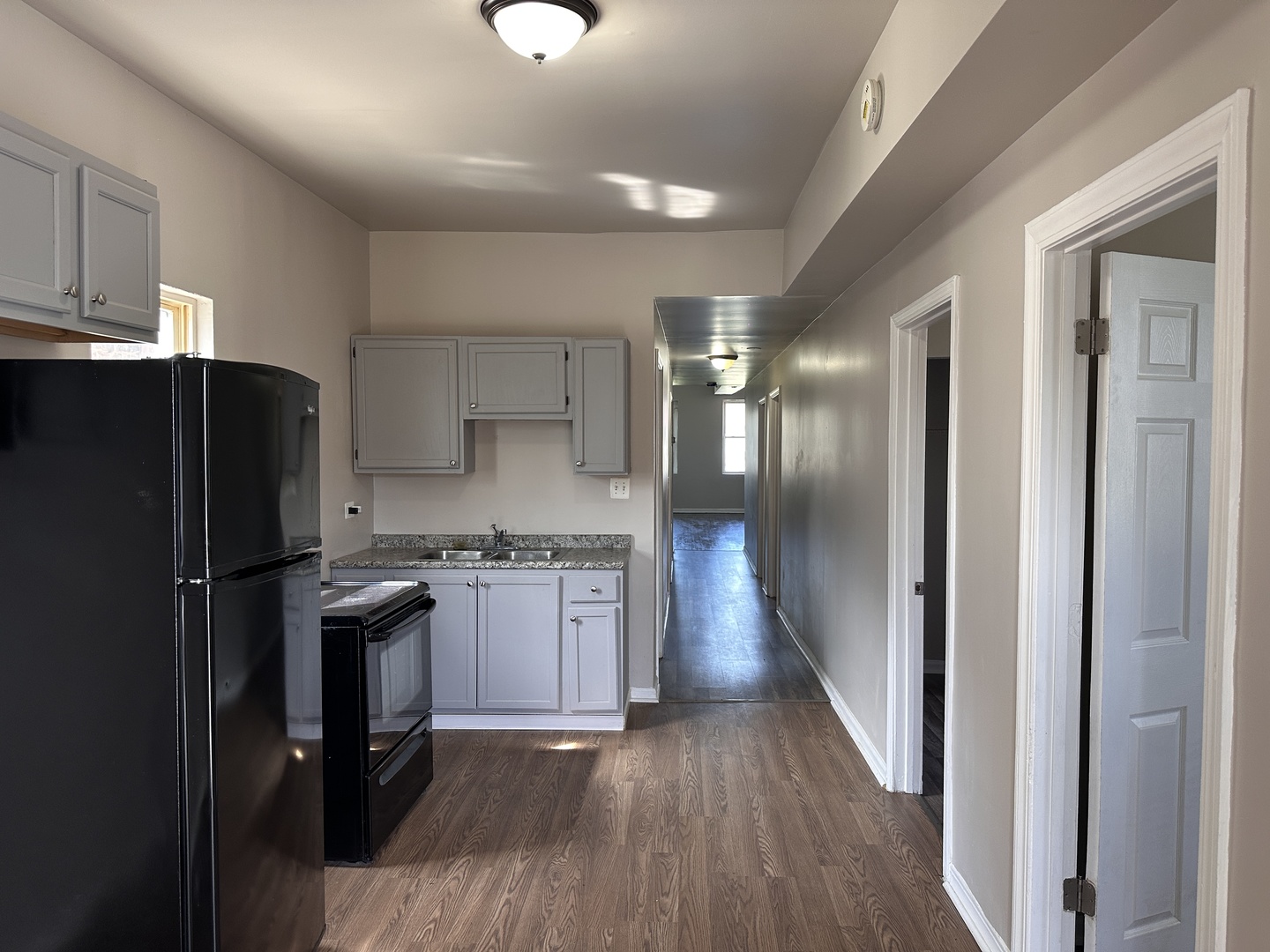 4107 West 16th Street Chicago, IL 60623 - Photo 2 of 29 a kitchen with stainless steel appliances granite countertop a refrigerator a sink dishwasher a stove and white countertops with wooden floor