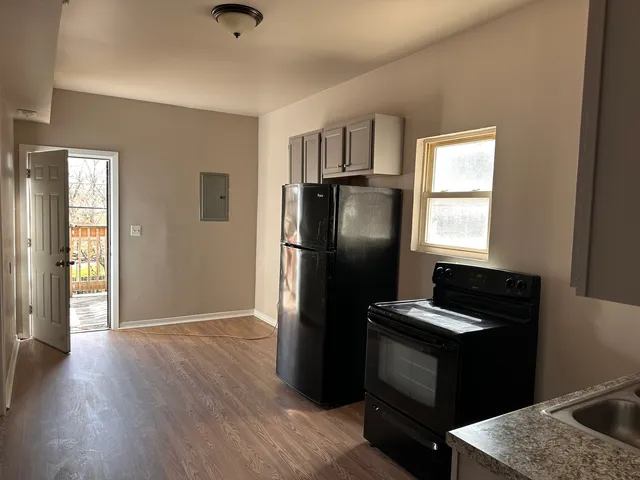 a kitchen with a refrigerator cabinets and wooden floor