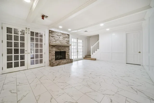 a view of empty room with a fireplace and window