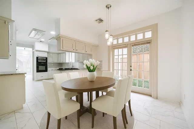 a view of a dining room with furniture and a potted plant
