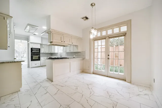 a view of kitchen with stainless steel appliances refrigerator oven and cabinets