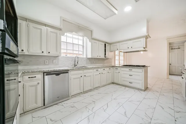 a kitchen with granite countertop white cabinets and white appliances