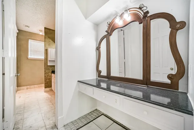 a bathroom with a mirror and vanity
