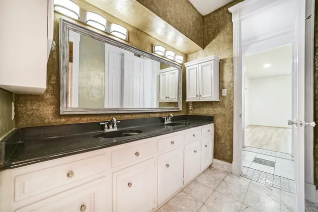 a bathroom with a granite countertop sink and a mirror