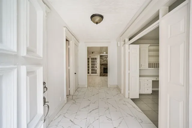 a view of a hallway with wooden shelves and entryway