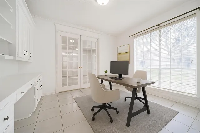 a view of a workspace with furniture and a window