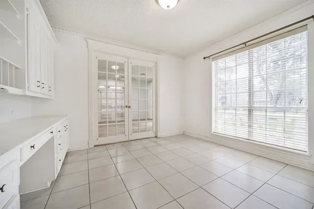 a view of an empty room with cabinet and a window