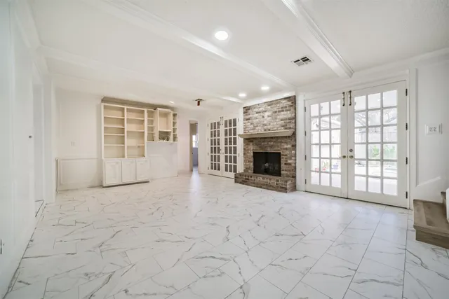 an empty room with windows and fireplace